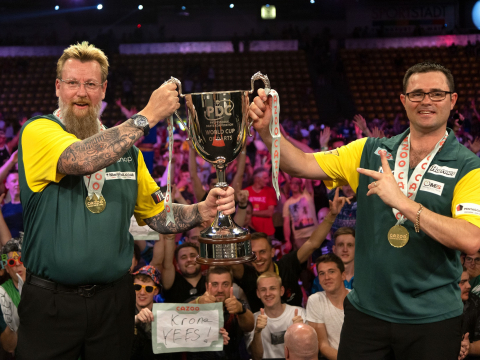 Simon Whitlock and Damon Heta lift the 2022 World Cup trophy